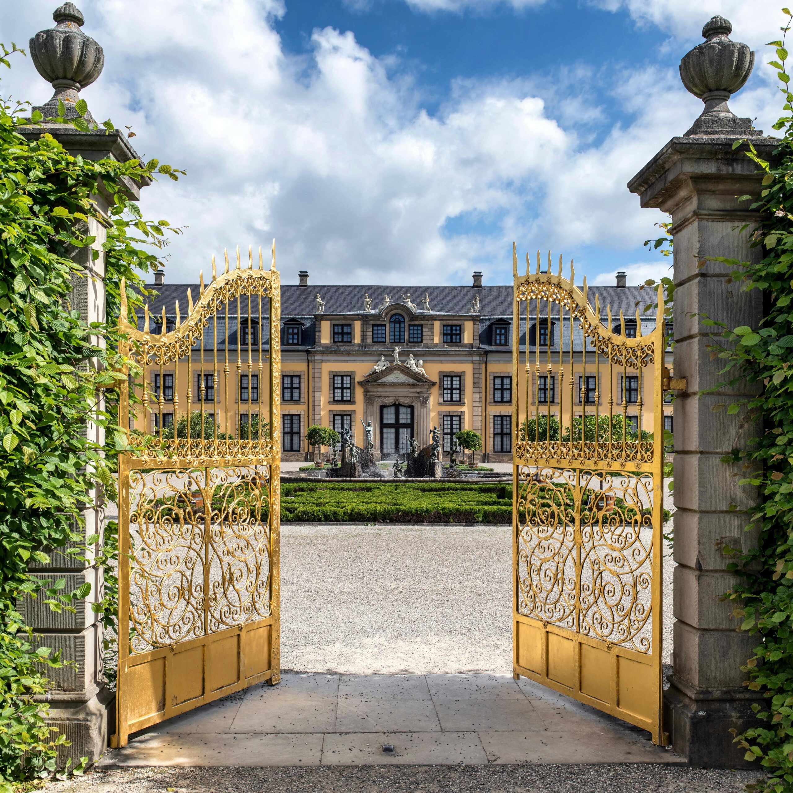 Golden gates open to the majestic Herrenhausen Palace in Hannover, Germany.